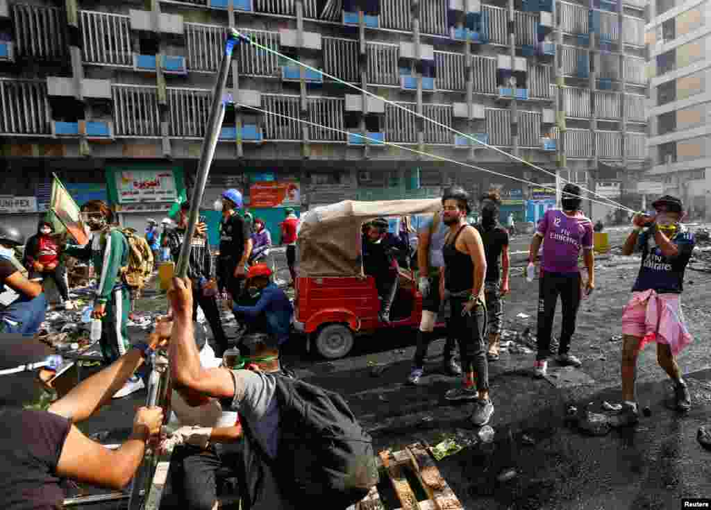 A demonstrator uses a slingshot during ongoing anti-government protests in Baghdad, Iraq.