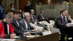 Mohammed Zahedin Labbaf, 3è à gauche, agent de la République islamique d'Iran, et la délégation américaine, à droite, écoutent la décision des juges de la Cour internationale de justice, La Haye, Pays-Bas, le 3 octobre 2018. 