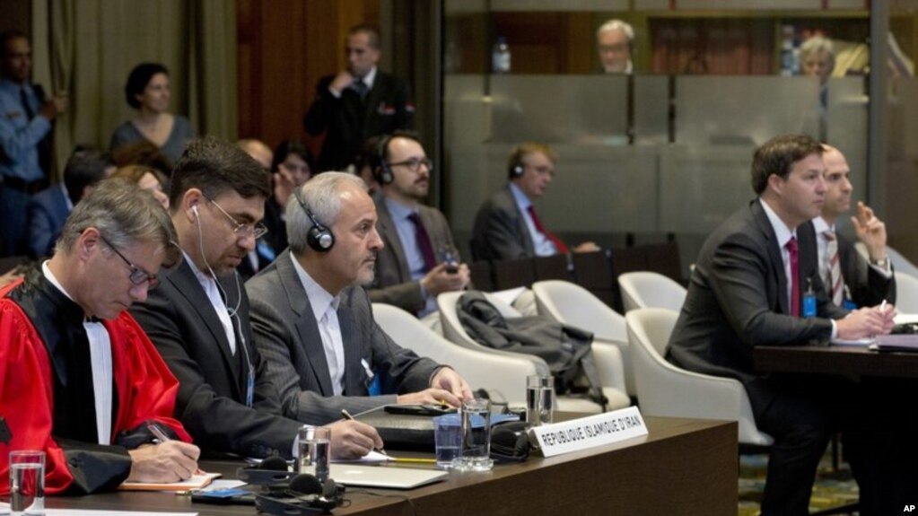 Mohammed Zahedin Labbaf, tercero a la izquierda, agente de la República Islámica de Irán, y la delegación estadounidense, a la derecha, escuchan al juez de la Corte Internacional de Justicia el 3 de octubre de 2018 en La Haya.