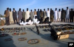 Arrested suspects and recovered weapons display for media by Pakistan paramilitary forces following a search operation in Shah Kass, an area of Pakistani Khyber tribal region along Afghan border, March 3, 2017.