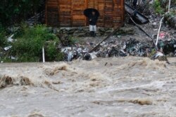 Seorang pria menyaksikan naiknya air di Rio Bermejo, San Pedro Sula, Honduras, pasca hantaman Badai Iota, Selasa, 17 November 2020.