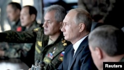 俄羅斯總統普京（右二）和國防部長紹伊古（右三）在靠近中國邊界的俄羅斯楚戈爾訓練場觀看“東方-2018”戰略軍演。 （2018年9月13日）