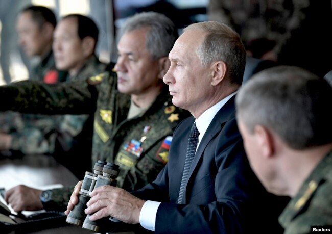 俄罗斯总统普京（右二）和国防部长绍伊古（右三）在靠近中国边界的俄罗斯楚戈尔训练场观看“东方-2018”战略军演。（2018年9月13日）
