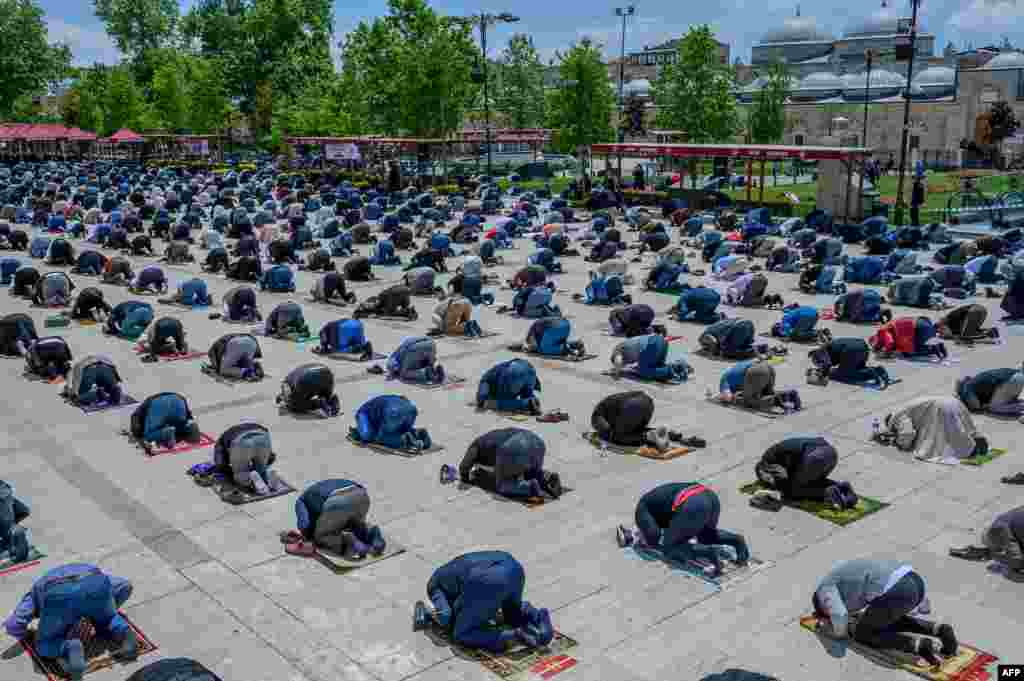 Jemaah Muslim yang mengenakan masker menjaga jarak aman untuk mencegah penyebaran Covid-19 selama salat Jumat (29/5) di luar Masjid Fatih di kota Istanbul, ketika pemerintah Turki mulai membuka kembali beberapa tempat ibadah.