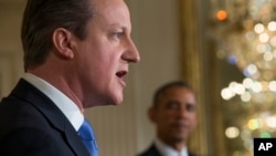 President Barack Obama listens as British Prime Minister David Cameron speaks during their joint news conference in the East Room of the White House, Jan. 16, 2015