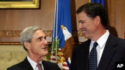 L’ancien directeur du FBI James Comey, à droite, discute avec son prédécesseur Robert Mueller récemment nommé procureur spécial pour l’enquête sur l'ingérence russe dans l'élection présidentielle américaine, à Washington, 4 septembre 2013.