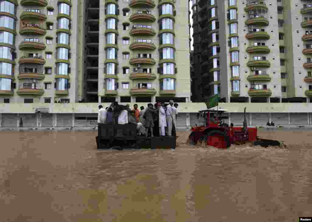 A tractor tows residents through flood waters to a safe place on the outskirts of Karachi, August 4, 2013.&nbsp;