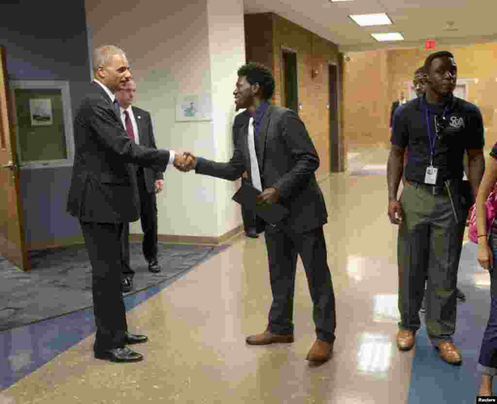 Attorney General Eric Holder shakes hands with Bradley J. Rayford, 22, following his meeting with students at St. Louis Community College Florissant Valley in Ferguson, Missouri, Aug. 20, 2014.