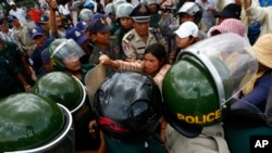 Tep Vanny, rear center, of Boeung Kak lake, scuffles with riot police officers during a protest rally against land eviction near the prime minister's residence, in Phnom Penh, file photo. 