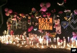 FILE - In this May 3, 2016 photo, candles burn at a memorial for Ashlynne Mike, who was abducted and murdered, on the Navajo Nation southwest of Farmington, New Mexico.