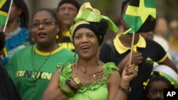 Pauline Brown waves her country's flag at the 50th anniversary of Jamaica's independence celebration in Miramar, Fla. Aug. 6, 2012. 