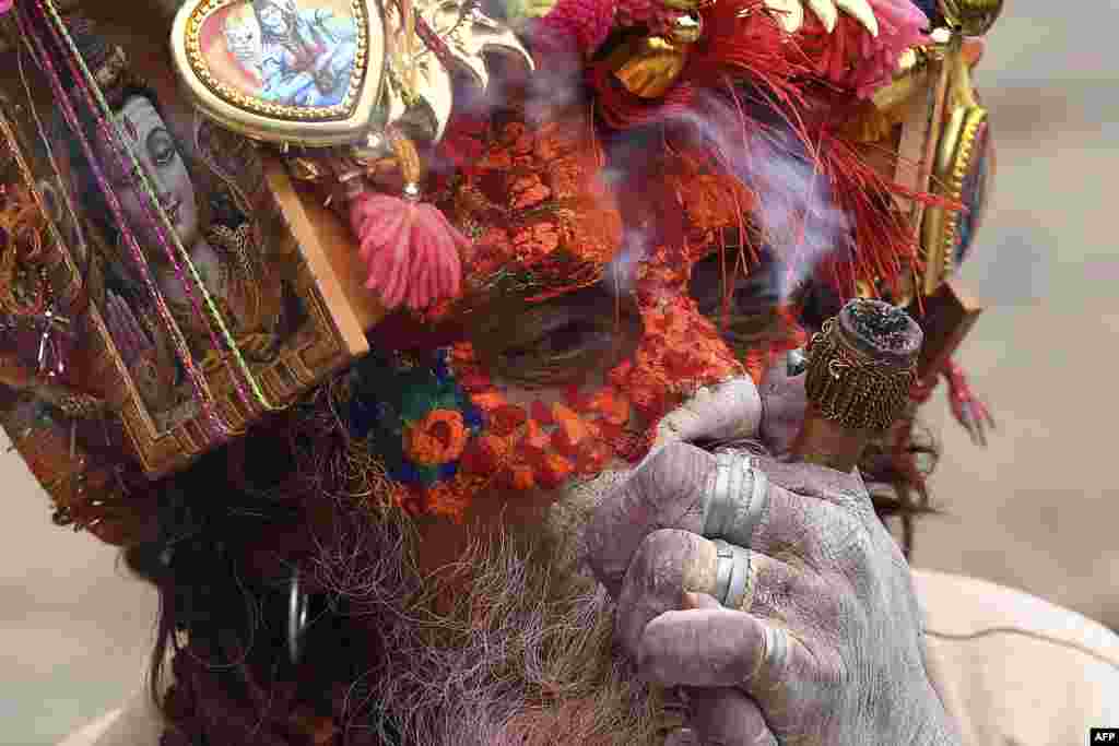 A sadhu (Hindu holy man) smokes marijuana using a &quot;chillum,&quot; a traditional clay pipe, as a holy offering during the Hindu festival Maha Shivaratri in Kathmandu, Nepal.