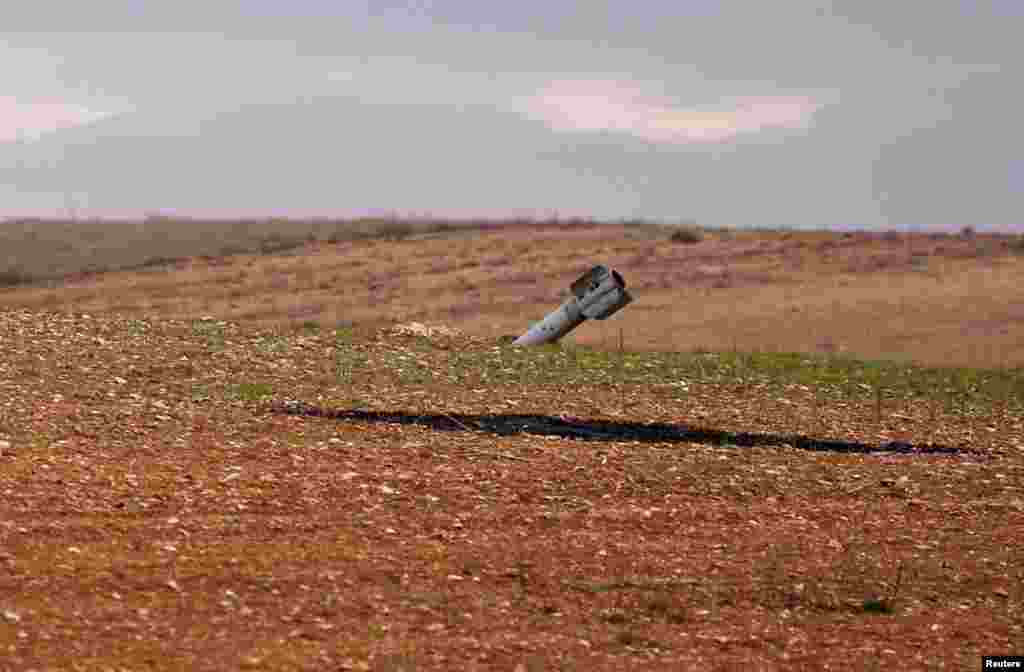 An unexploded missile is seen in a field off the road outside Maarat al-Numan, Syria, Jan. 30, 2020.