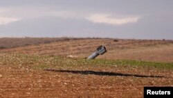 Sebuah rudal yang tidak meledak terlihat di lapangan di luar jalan raya di luar Maarat al-Numan, Suriah, 30 Januari 2020. (Foto: Reuters)