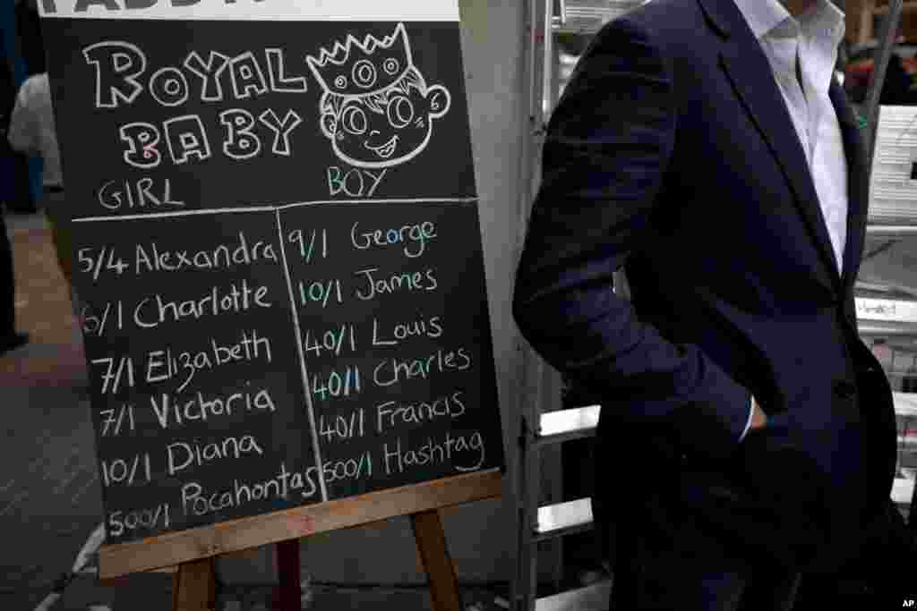 A representative from a betting company stands by a board detailing odds on different names for the royal baby outside St. Mary&#39;s Hospital, Lindo Wing in London.&nbsp;