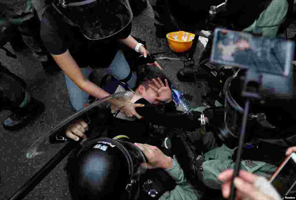 Agentes de la policía antidisturbios detienen a un manifestante contra la ley de extradición durante una marcha en el barrio de Sham Shui Po en Hong Kong, China, 11 de agosto de 2019. Un video del incidente fue publicado por el sitio web Hong Kong Free Press.&nbsp;