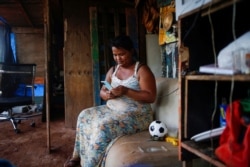 Sirqueira uses a cell phone in her home during the coronavirus disease (COVID-19) pandemic in Brasilia. (REUTERS/Adriano Machado)