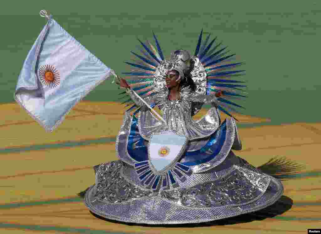 A dancer holds an Argentina flag as she performs during the closing ceremony at the Maracana stadium in Rio de Janeiro, July 13, 2014.