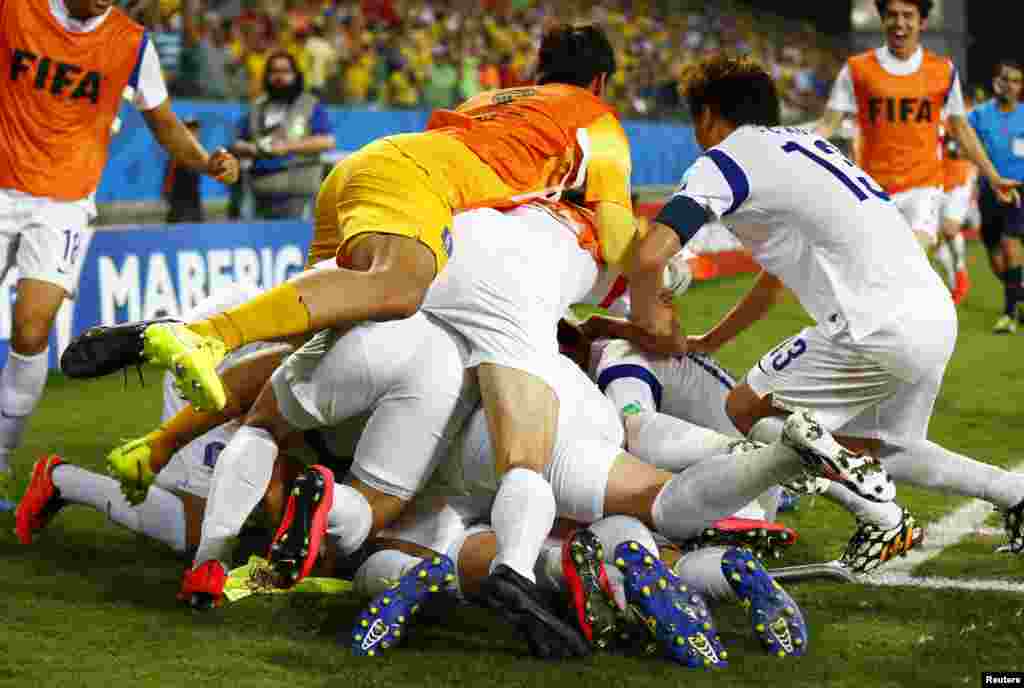 Pemain sepakbola nasional Korea Selatan menindih rekannya Lee Keun-ho saat merayakan golnya melawan Rusia dalam pertandingan grup H Piala Dunia 2014 di arena Pantanal, di Cuiaba, 17 Juni 2014.