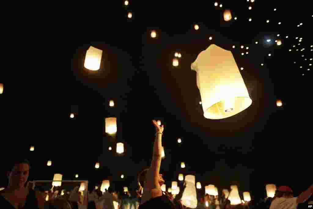 Jenny Brand, from Sweden (C), who had friends that were victims of the Asian tsunami, releases a lantern which symbolizes the releasing of spirits, amid hundreds of others during a service to mark the 10th anniversary of the disaster, in Ban Nam Khem, Thailand.
