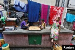 FILE - Boys play at a slum area in Kolkata, India, June 3, 2016.