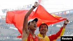Le Chinois Qi Shun fête sa victoire après avoir remporté le marathon T 12 au stade national, lors des Jeux paralympiques de Rio, le 17 septembre 2008.