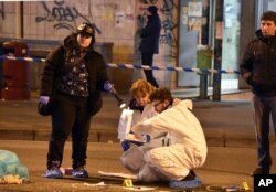 Italian forensic police inspect an area after a shootout between police and a man near a train station in Milan's Sesto San Giovanni neighborhood, Italy, Dec. 23, 2016.