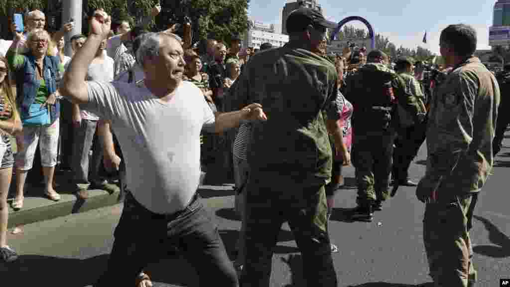 A man throws an egg at captured Ukrainian army prisoners as they are escorted by Pro-Russian rebels in a central square in Donetsk, eastern Ukraine, Aug. 24, 2014. 