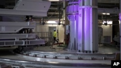 A worker walks through large assembly tools in the assembly hall of the ITER ( the International Thermonuclear Experimental Reactor). The project aims to replicate the energy of the sun to create nuclear fusion reactions as a way to produce power. (AP Photo)