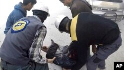 This photo provided by the Syrian Civil Defense White Helmets, which has been authenticated based on its contents and other AP reporting, shows members of the Syrian Civil Defense group helping a wounded man after airstrikes hit eastern Ghouta.