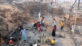 Rohingya refugees stand at the site of Monday's fire at a refugee camp in Balukhali, southern Bangladesh, Tuesday, March 23, 2021. (AP Photo/ Shafiqur Rahman)