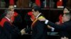 Venezuela's President Nicolas Maduro, center, shakes hands with Supreme Court President Maikel Moreno as his presidential sash is adjusted, after he took the oath of office in Caracas, Jan. 10, 2019. 