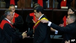 Venezuela's President Nicolas Maduro, center, shakes hands with Supreme Court President Maikel Moreno as his presidential sash is adjusted, after he took the oath of office in Caracas, Jan. 10, 2019. 