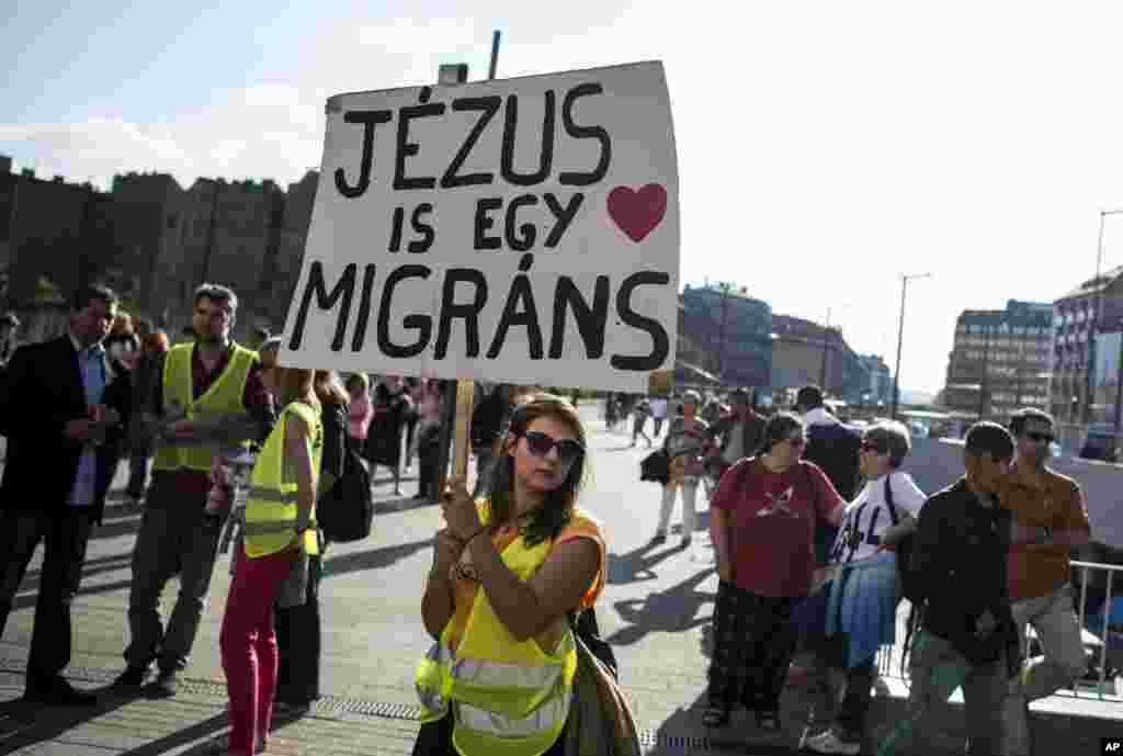 Across Europe, protestors took part in demonstrations in solidarity with migrants and refugees Saturday. Here, a demonstor carries a sign at the Keleti railway station in Budapest, Hungary.