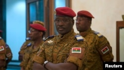 Burkina Faso Prime Minister Isaac Zida listens as an official reads the names of transitional government ministers in Ouagadougou Nov. 23, 2014.