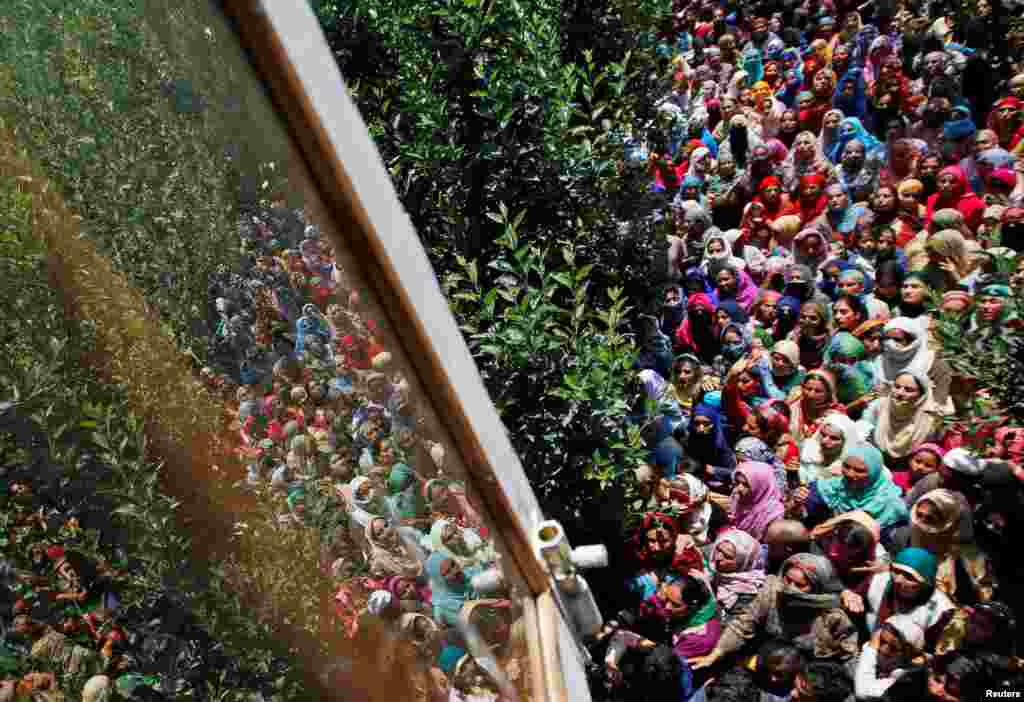 People watch the body of Imran Ahmad Bhat, a suspected militant who was killed during a gun battle with Indian security forces, during his funeral procession in Arihal village in South Kashmir&#39;s Pulwama district.
