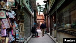 A shopkeeper waits for tourists near rows of closed shops at a popular tourist area named "Khan el-Khalili" in the al-Hussein and Al-Azhar districts in old Islamic Cairo, Egypt, Feb. 23, 2017.