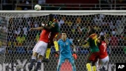 Egypt goalkeeper Essam El Hadary, center, watches as Cameroon's Nicolas Nkoulou, 2nd left, jumps to score his side's first goal during the African Cup of Nations final soccer match between Egypt and Cameroon at the Stade de l'Amitie, in Libreville, Gabon,
