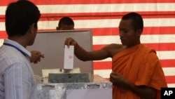 Cambodian Buddhist monk, right, casts his ballot in local elections at Wat Than pagoda's polling station in Phnom Penh, file photo. 