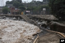 Train tracks lay destroyed in a flooded river in the Chosica district of Lima, Peru, Sunday, March 19, 2017. Intense rains and mudslides over the past three days have wrought havoc around the Andean nation.
