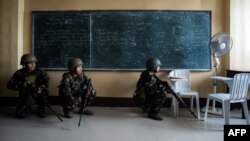 Philippine Army Scout Rangers crouch in a classroom during a mission to flush out Islamist militant snipers in Marawi, on the southern island of Mindanao, June 6, 2017. 