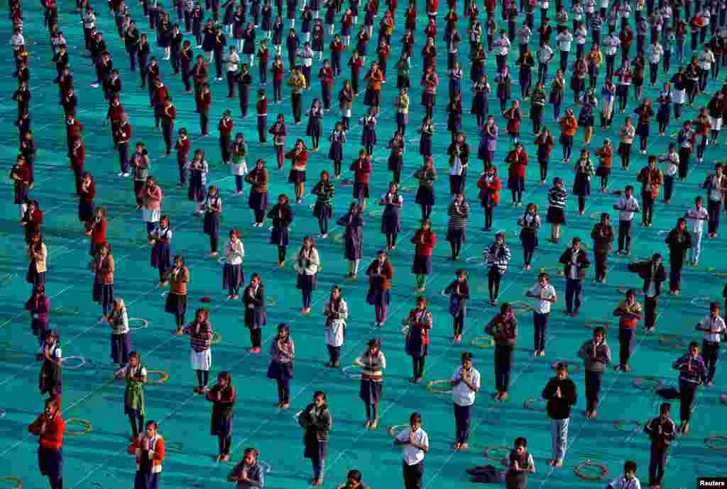 Para pelajar melakukan yoga massal dalam acara di kota Ahmedabad, India.