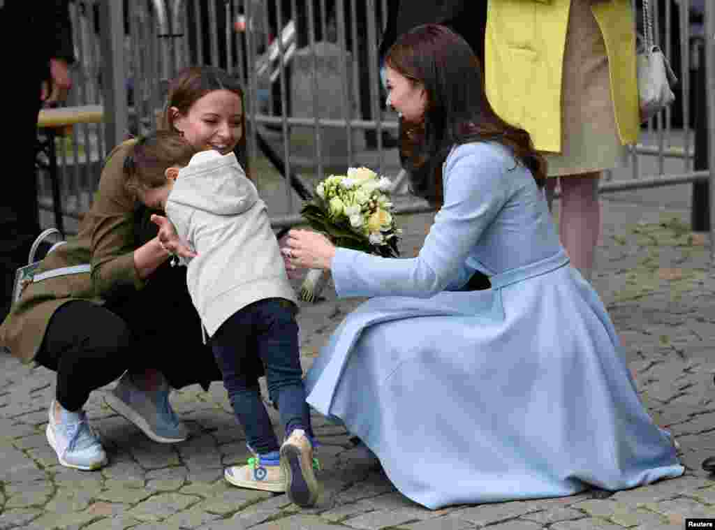 A young boy reacts after handing a bouquet of flowers to Britain's Catherine, the Duchess of Cambridge, in Luxembourg.