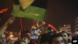 People celebrate the recent news of uprising in Tripoli against Moammar Gadhafi's regime at the rebel-held town of Benghazi, Libya, early Sunday, Aug. 21, 2011