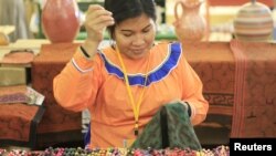 A woman from the Amazon region weaves a textile during the "Ruraq Maki", or handmade, artisan fair in Lima, Peru. 