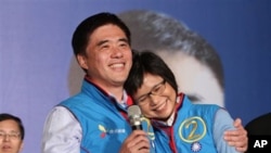 Nationalist Party mayoral candidate Hau Ling-bin, left, holds his wife and celebrate Hau's victory, in Taipei, Taiwan, 27 Nov 2010