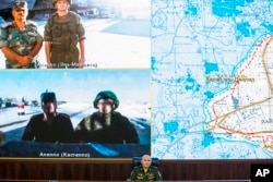 Lt.-Gen. Sergei Rudskoi, center, of the Russian Military General Staff listens to Russian and Syrian officers during a video call, as a Syrian army facility is displayed on screen, at a Russian Defense Ministry building in Moscow, Russia, Sept. 12, 2016.