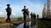 Myanmar police officers patrol along the fence bordering Bangladesh in Maungdaw, Rakhine State, Myanmar, Oct. 14, 2016. New reports accuse soldiers of brutality against Myanmar's long-persecuted Rohingya Muslims.