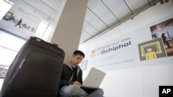 一位马来西亚人在阿姆斯特丹史基浦机场机场使用笔记本电脑。