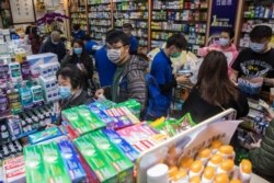 Para konsumen (tengah depan) meninggalkan apotek setelah membeli masker di Hong Kong, 30 Januari 2020. Di Hong Kong terjadi kepanikan karena orang-orang berebut membeli masker untuk mencegah agar tidak terjangkit virus corona. (Foto: AFP)
